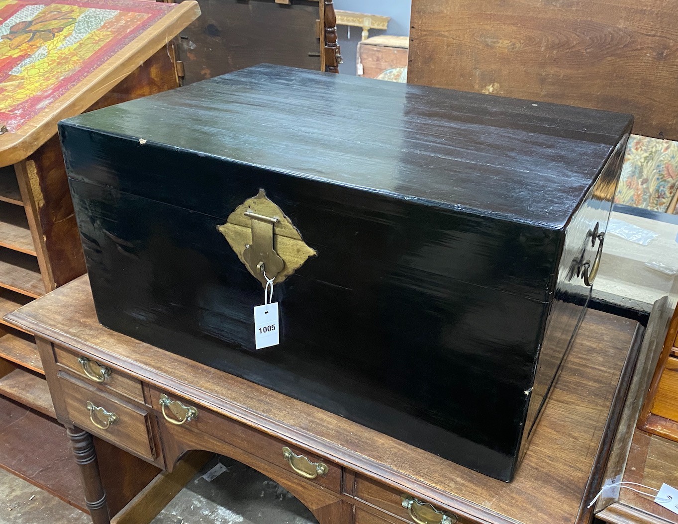 A Chinese black lacquered wooden trunk, with brass loop handles, width 77cm